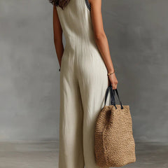 Beige sleeveless jumpsuit with high-neck zip front and wide-leg silhouette