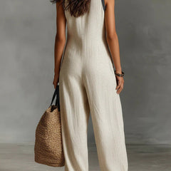 Beige sleeveless jumpsuit with high-neck zip front and wide-leg cut, side view