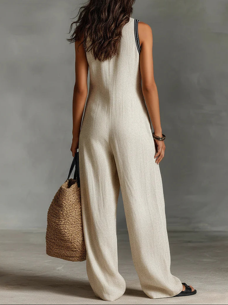 Beige sleeveless jumpsuit with high-neck zip front and wide-leg cut, side view