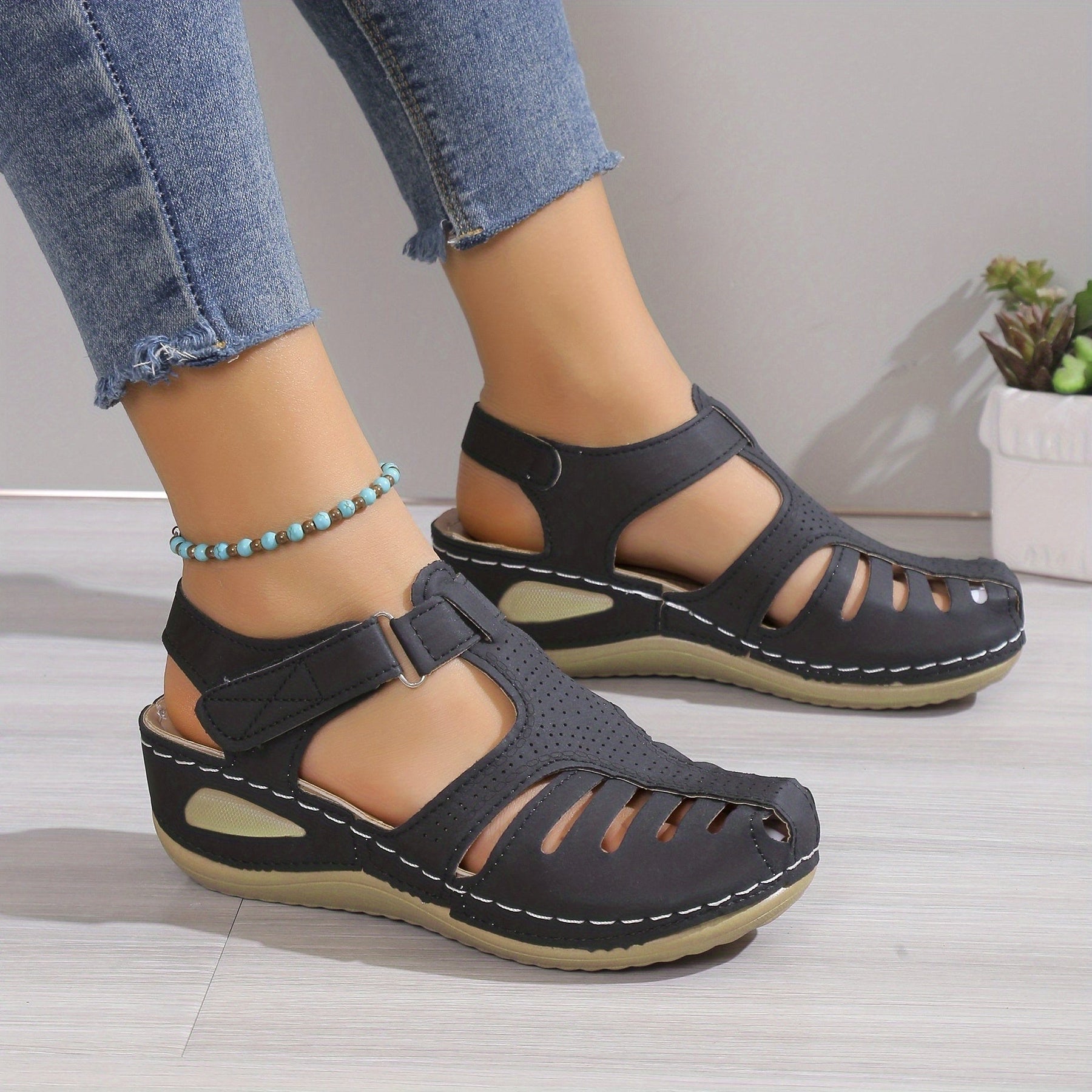 Sandali comfort neri con cinturini incrociati, tagli decorativi e suola rialzata
