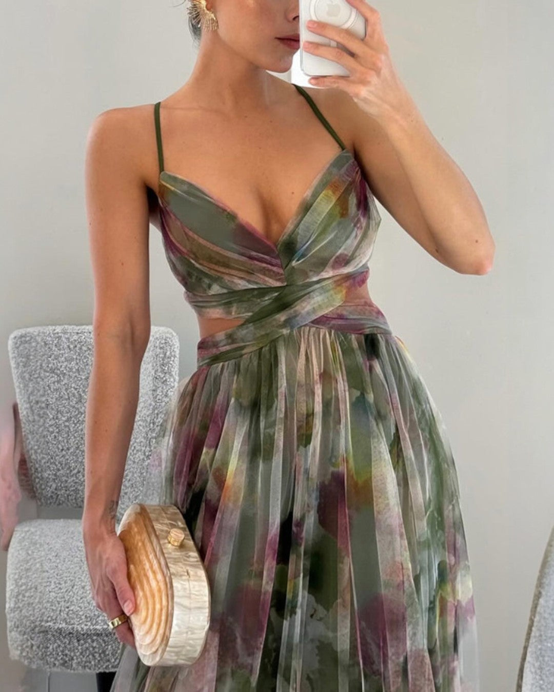 Abito lungo floreale verde-viola con bretelle sottili e corsetto annodato, gonna ampia.