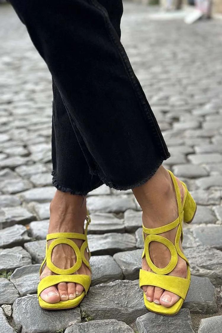 Yellow open-toe flat sandals with crisscross straps and ring cutouts, ankle tie