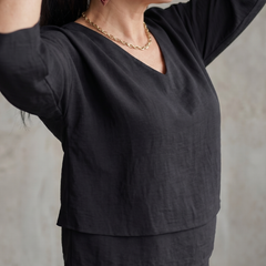 Black layered V-neck top detail with short sleeves and layered jewelry