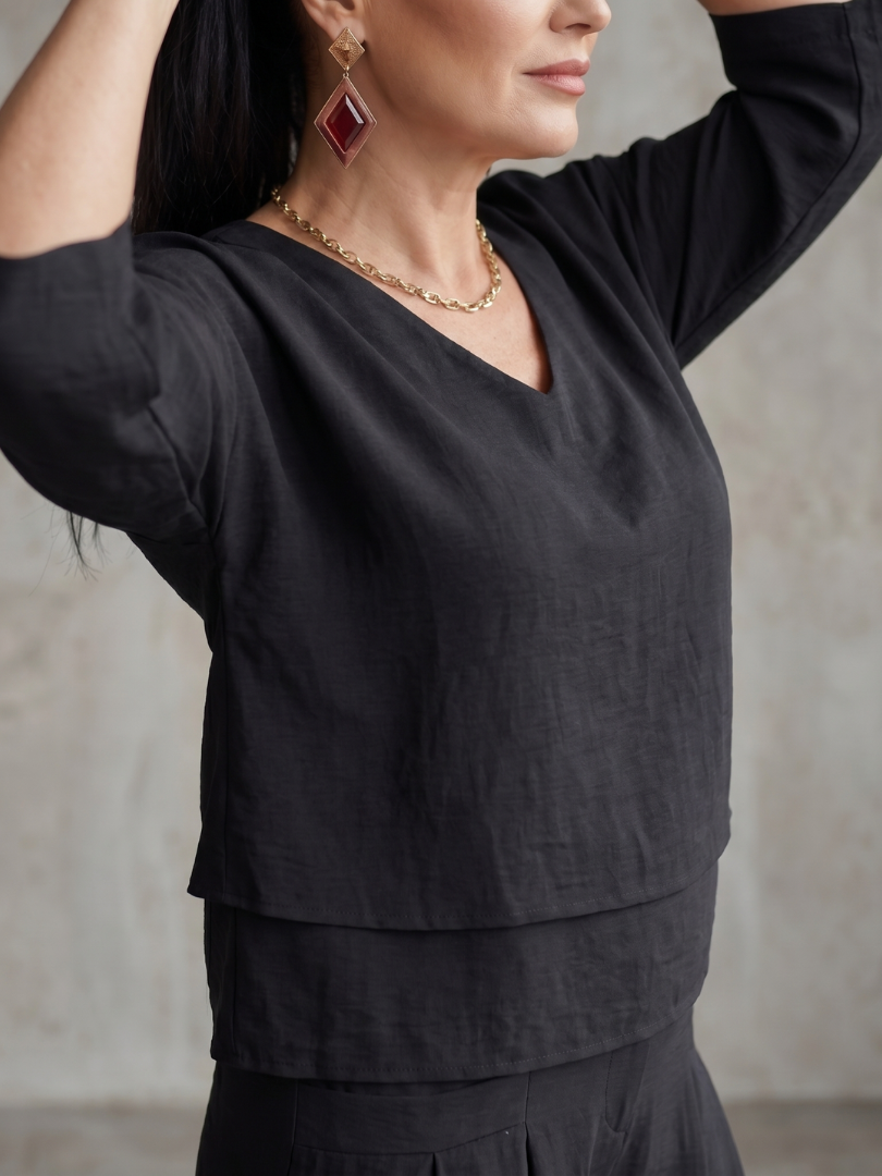 Black layered V-neck top detail with short sleeves and layered jewelry