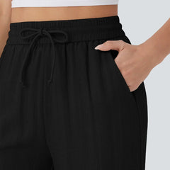 Black wide-leg trousers: elastic waistband with drawstring bow detail.