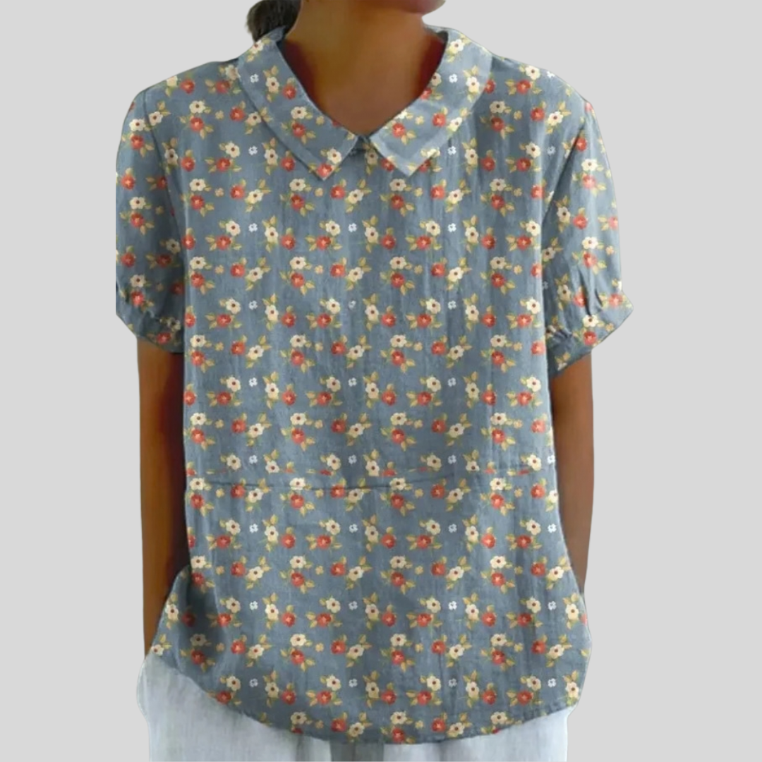 Top in tessuto azzurro a fiori con scollo a V e maniche corte