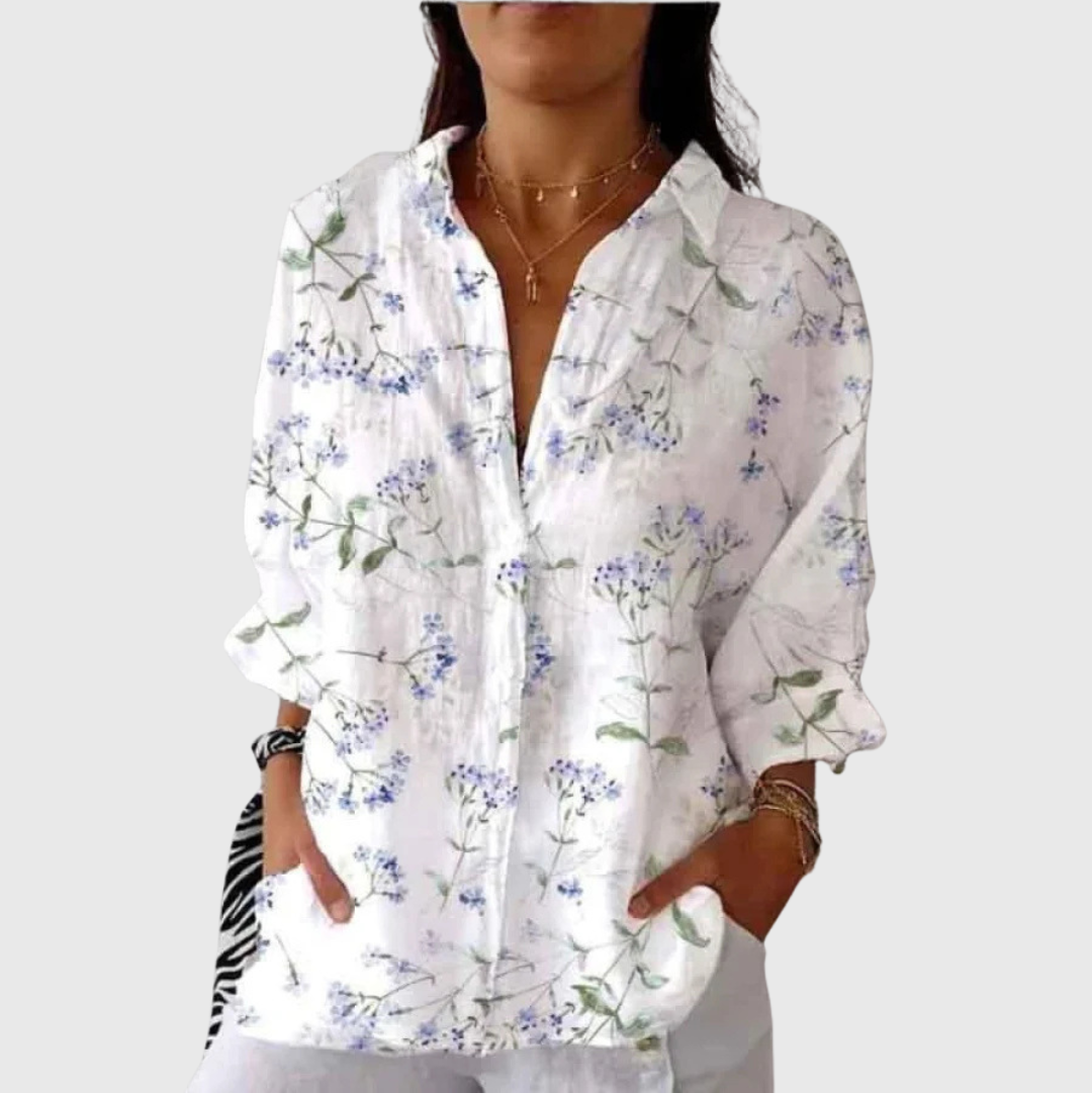 Blusa leggera bianca con stampa floreale blu e verdi, scollo a bottoni