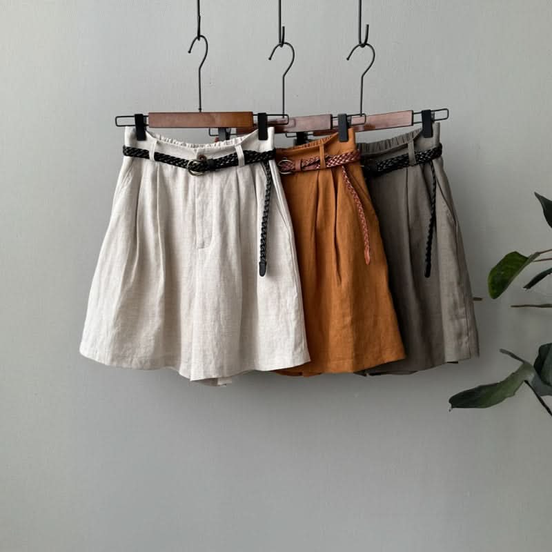 Linen shorts in beige, orange, and gray with braided tie belt on hangers