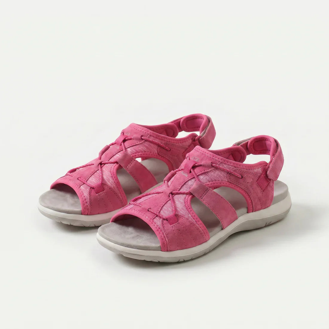 Sandali ortopedici fucsia con cinturini a strappo e suola ammortizzata.