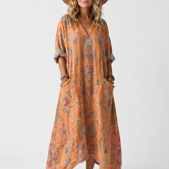 Orange printed midi dress with notch neckline, oversized pockets, and relaxed drape