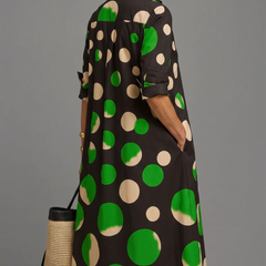 Abito midi nero con fantasia cerchi verdi e beige, maniche a 3/4 arrotolate, bottoni