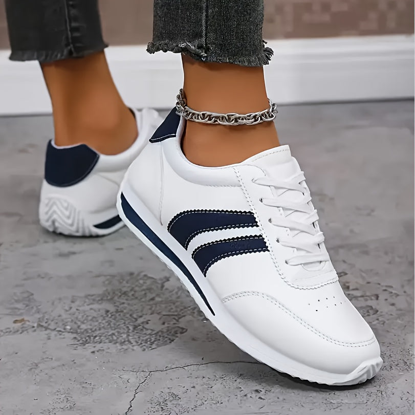 Scarpe leggere bianche con inserti blu, lacci e suola sagomata; naso rotondo