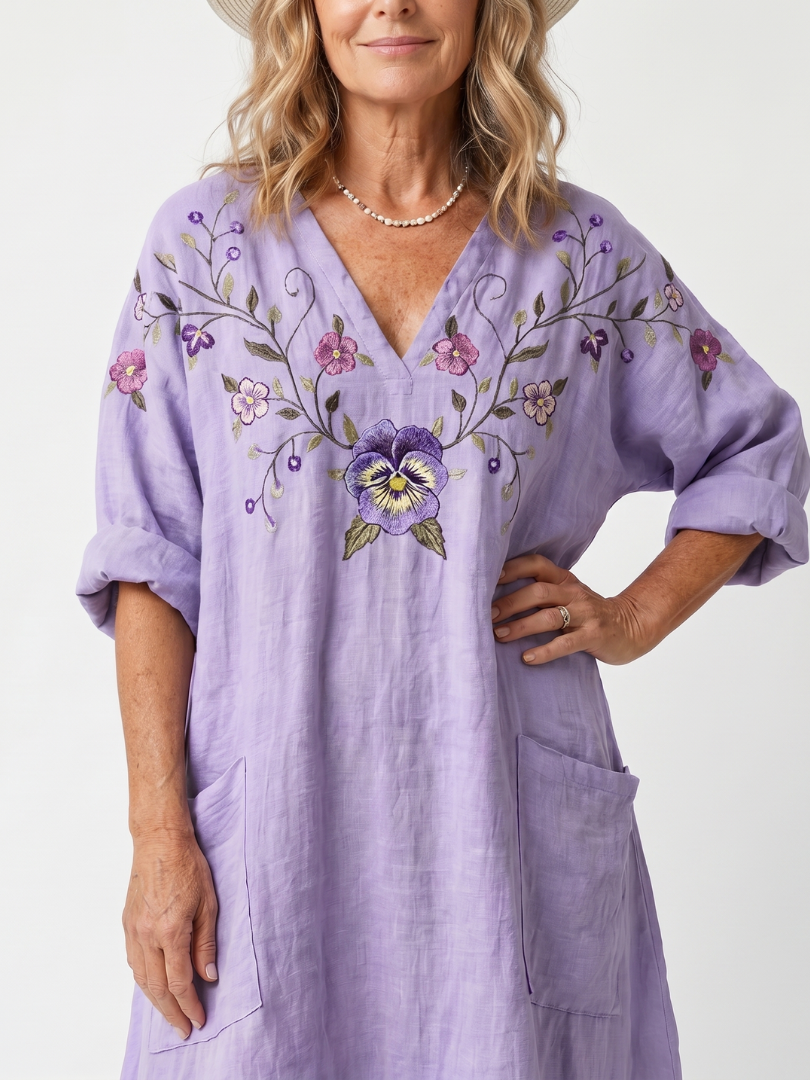 Purple midi dress close-up: floral embroidered V-neck, elbow-length puff sleeves and pocket