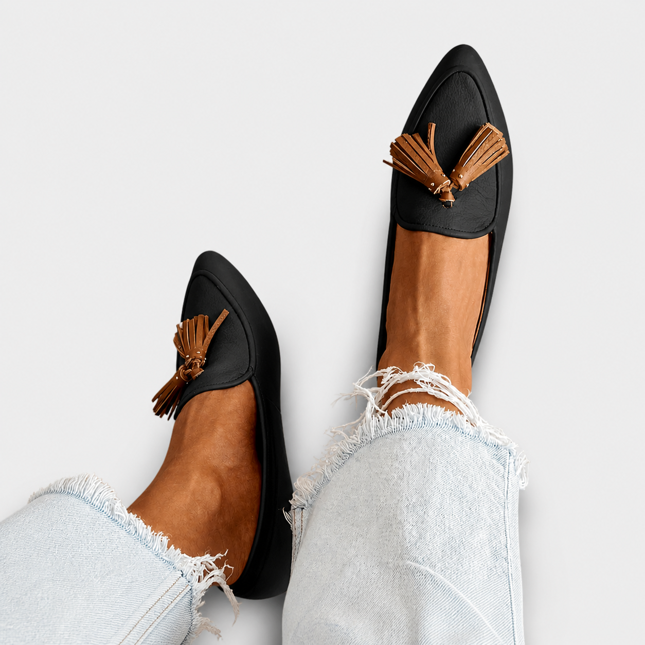 Mocassini neri con frange in pelle e punta arrotondata, dettaglio intreccio sul collo.
