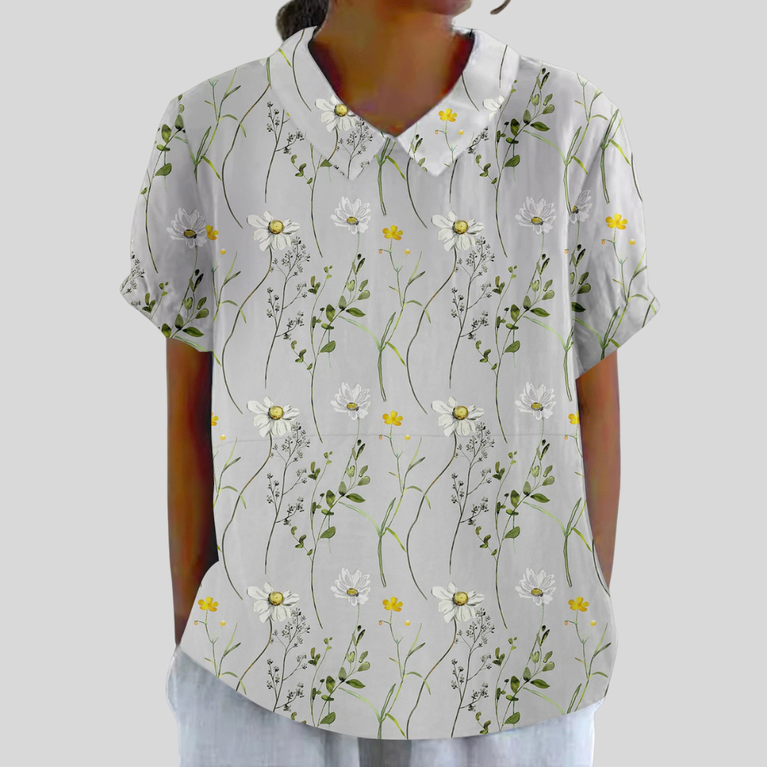 Top floreale bianco con colletto e bottoni, maniche corte, fantasia margherite e fiori