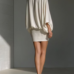 White back of loose V-neck blouse with pleated sleeves and mini skirt