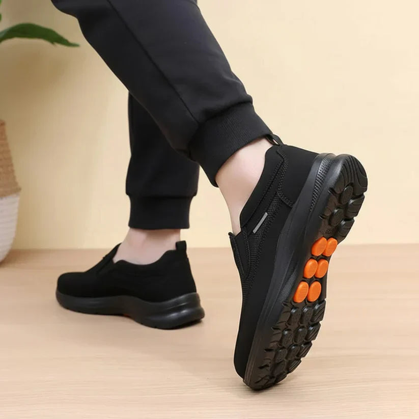 Scarpe casual ortopediche nere con suola a rilievi e dettagli arancioni
