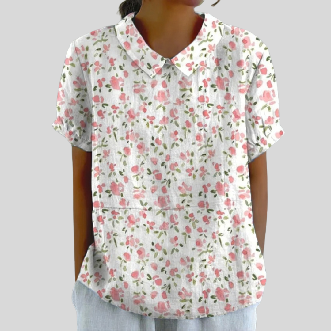 Top floreale bianco con fiori rosa/verde, scollo a V, maniche corte