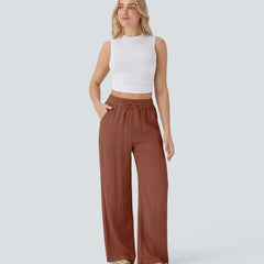 Rust brown wide-leg trousers with elastic waistband and drawstring, relaxed drape.
