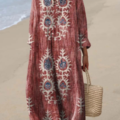 Rust red boho maxi dress with white folk embroidery, V-neck, long sleeves, loose drape.