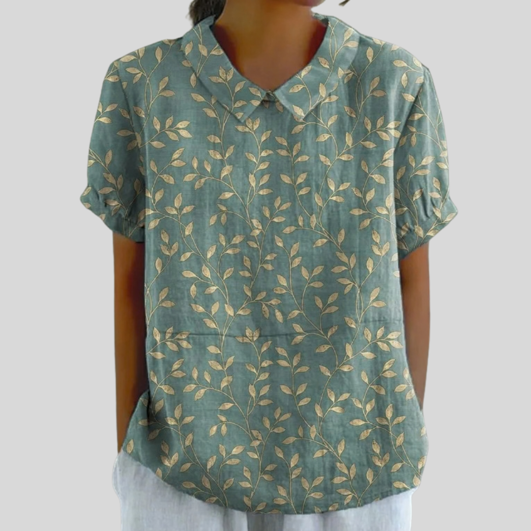 Top in tessuto verde petrolio con stampa floreale a foglie color senape, maniche corte