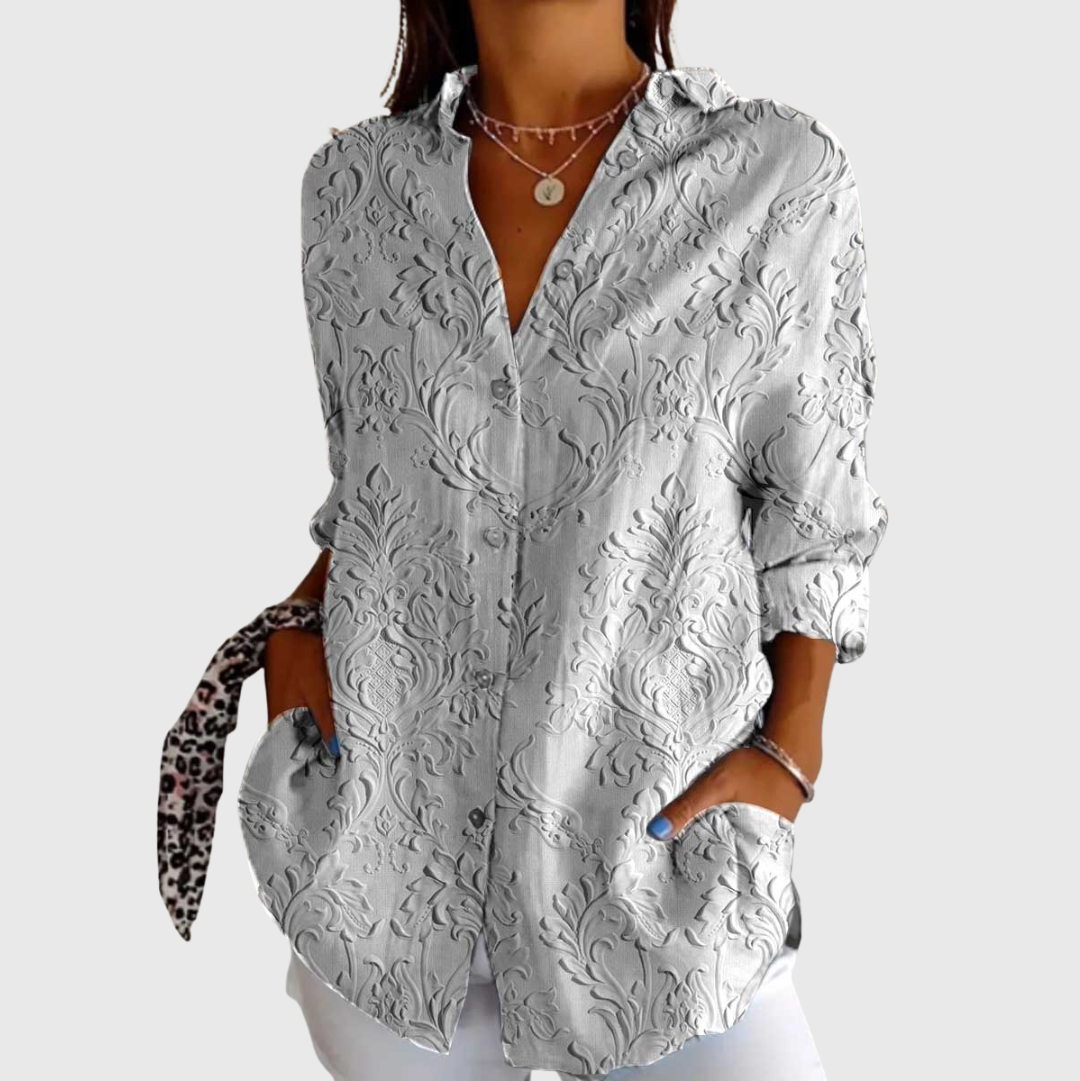 Blusa leggera grigia con motivo a rilievo, scollo a V e bottoni, maniche a sbuffo