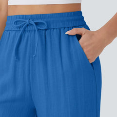 Close-up of blue drawstring waist on wide-leg trousers with elastic waistband.