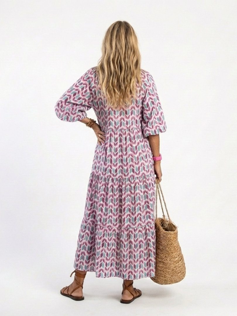 Tiered midi dress back view with geometric lilac-teal pattern and 3/4 puff sleeves