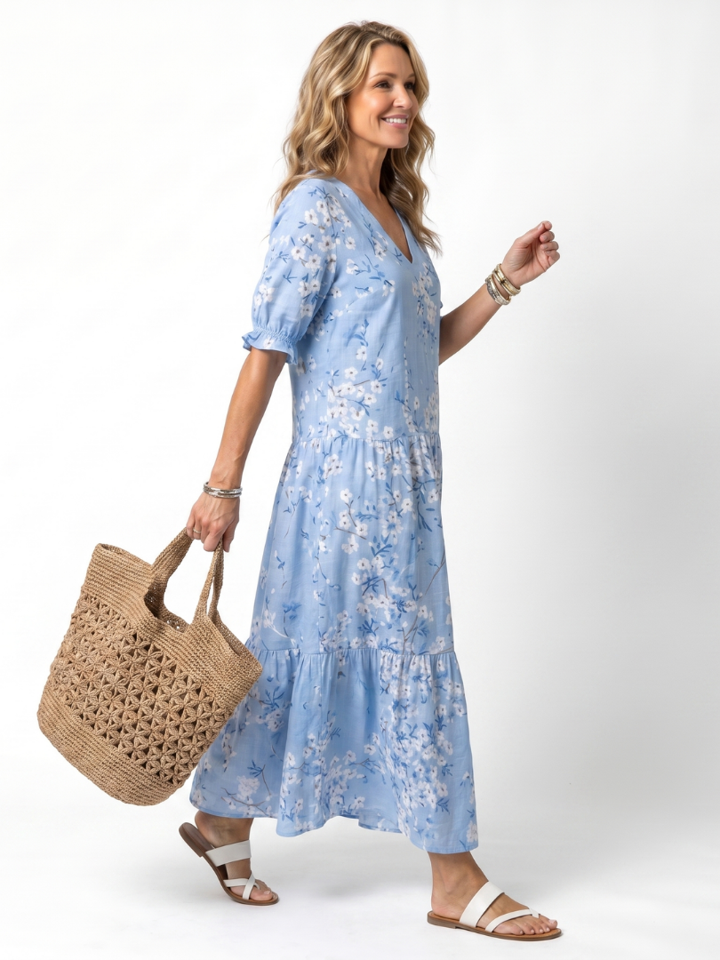 Blue floral midi dress with V-neck, short puff sleeves, and flowing tiered skirt