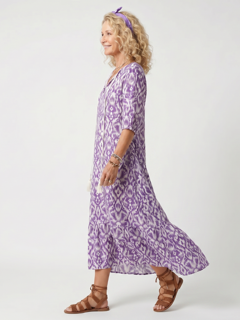 Purple printed midi dress with V-neck and tassel tie, side view, flared skirt