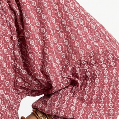 Geometric print fabric close-up on dusty rose long-sleeve dress, gathered cuff