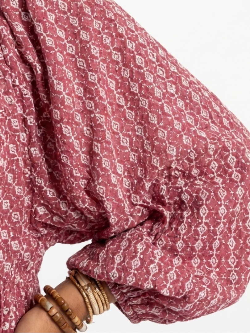 Geometric print fabric close-up on dusty rose long-sleeve dress, gathered cuff