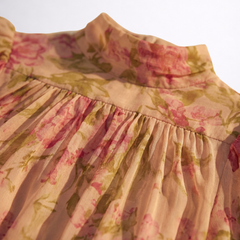 Dettaglio abito in chiffon floreale: arricciature al collo e balza in vita