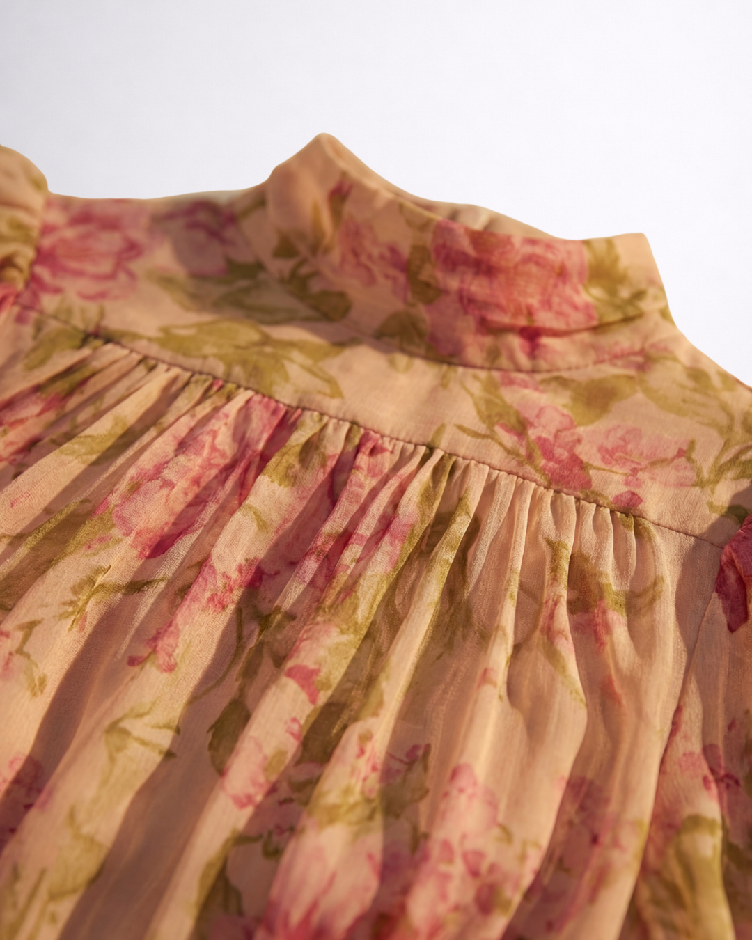 Dettaglio abito in chiffon floreale: arricciature al collo e balza in vita
