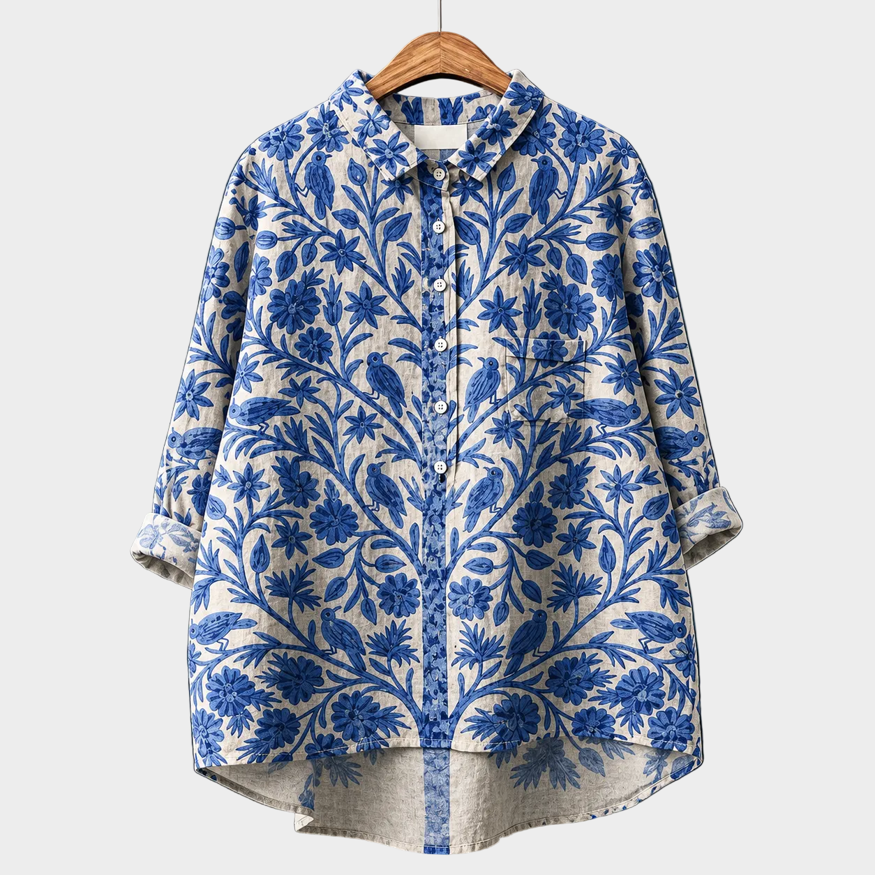 Blusa estiva in tessuto leggero con motivo floreale blu e bianco, maniche lunghe.