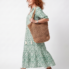 Green patterned V-neck midi dress with short sleeves and tiered skirt, side view