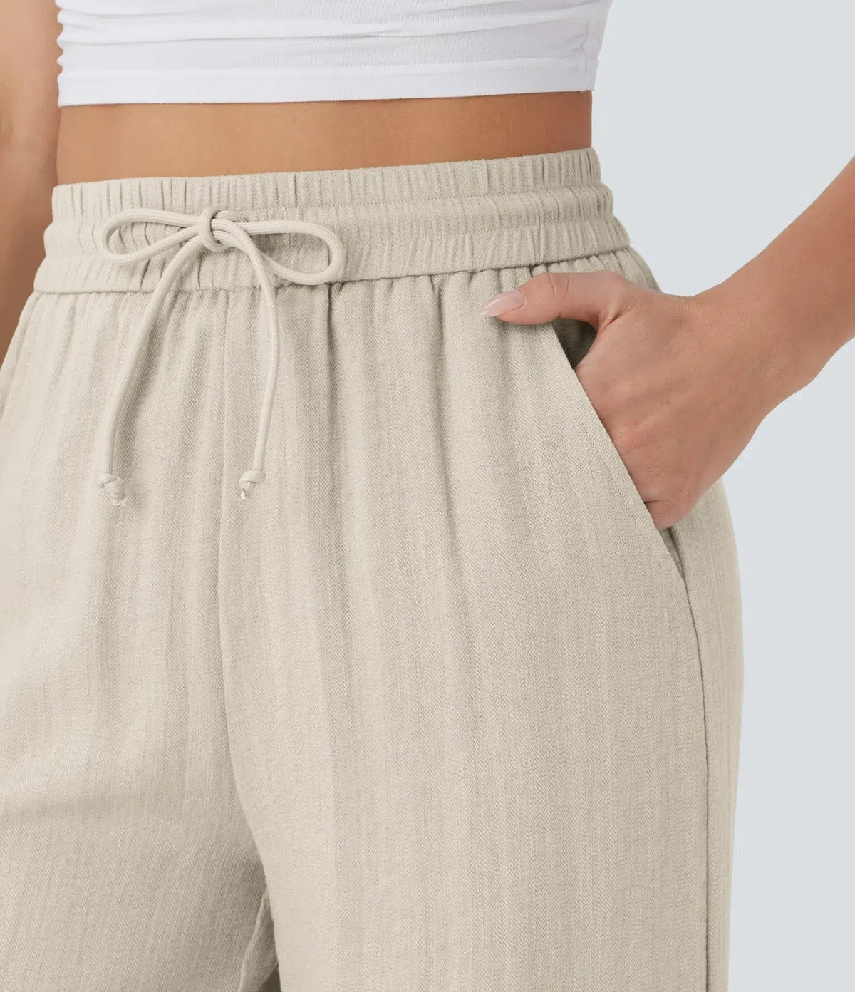 Beige elastic waist trousers with drawstring ties detail at waistband