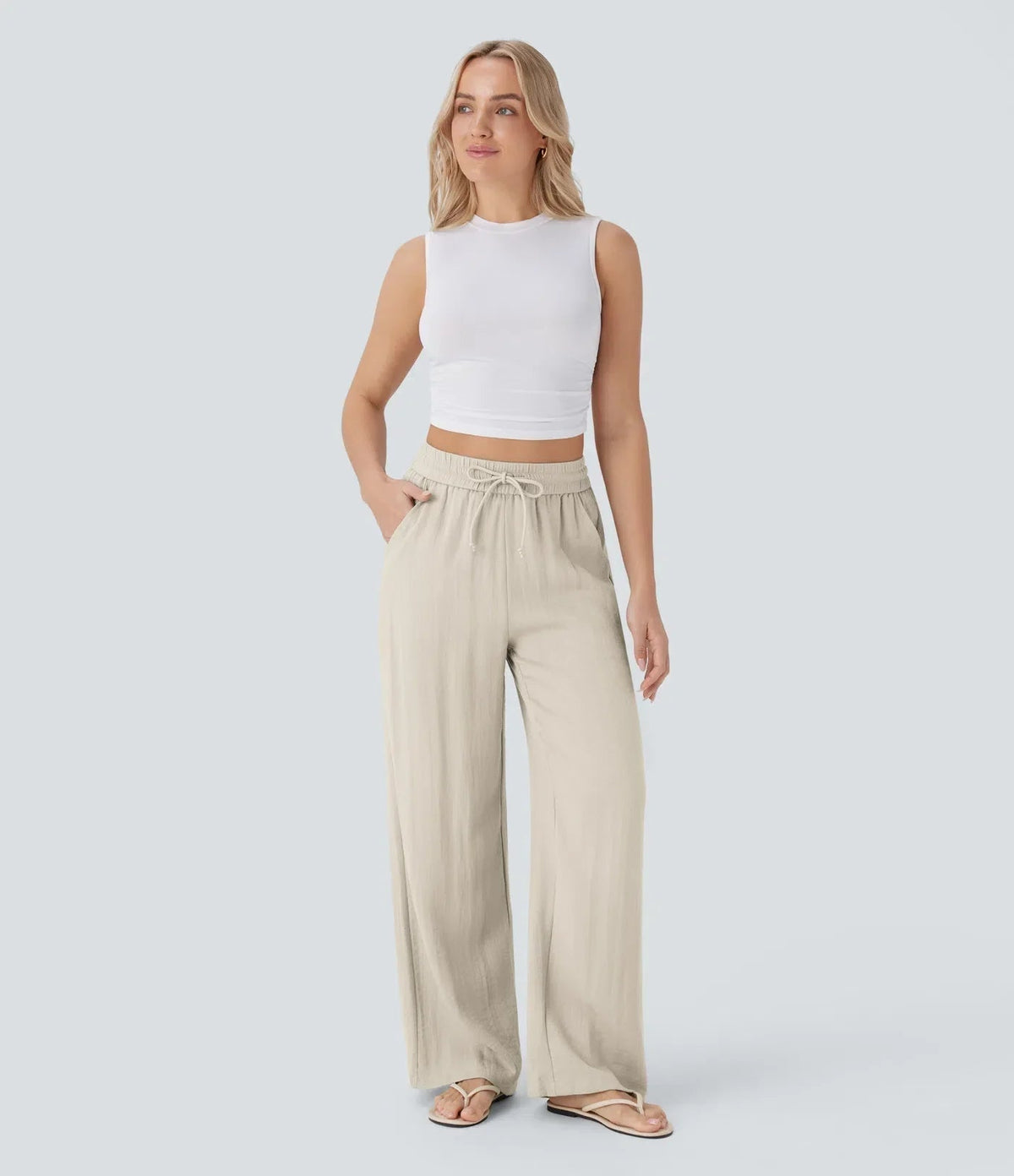Beige wide-leg trousers with elastic waistband and drawstring ties, full length view