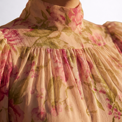 Dettaglio abito in chiffon floreale: collo alto e balze arricciate sul busto