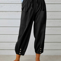 Black high-waist drawstring jogger trousers with side pockets and snap cuffs.