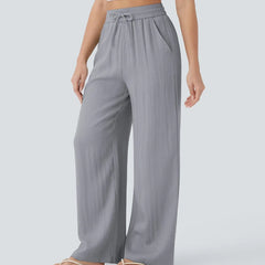 Grey wide-leg trousers with elastic waistband and drawstring, loose flowing fit.