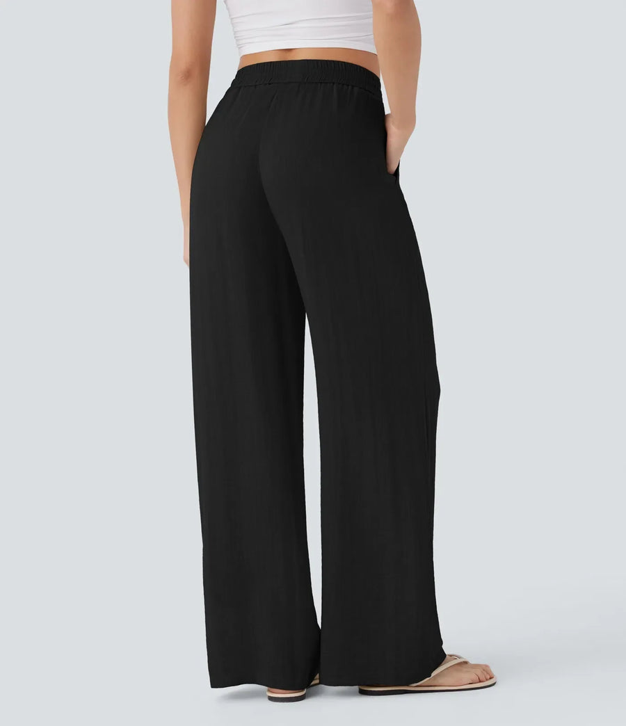 Black wide-leg trousers with elastic waist and drawstring, wide relaxed legs.