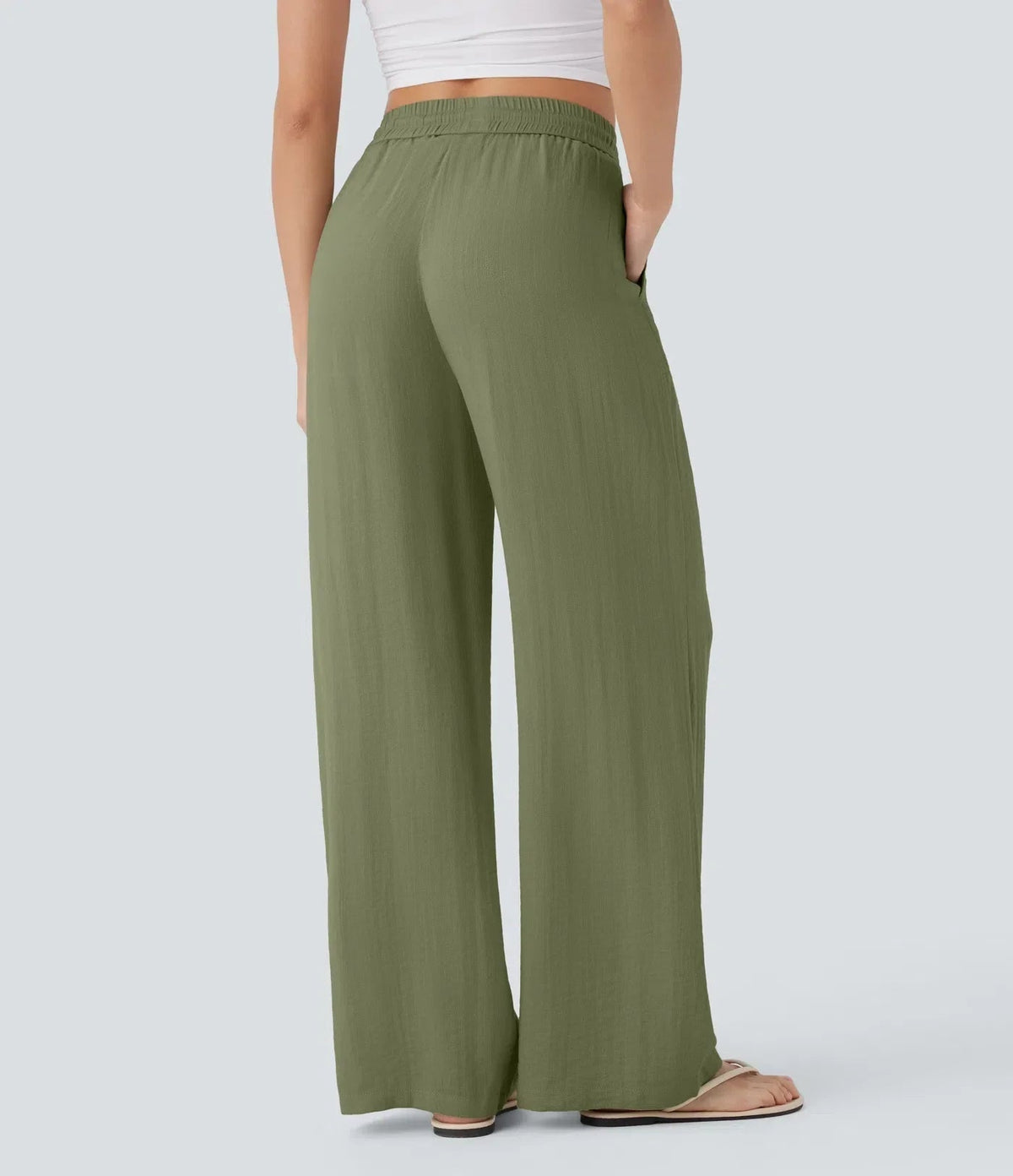 Olive green wide-leg trousers with elastic waist and drawstring, long and loose.