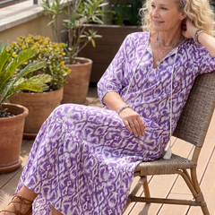 Purple printed midi dress with tassel tie, V-neck, flared skirt, seated model