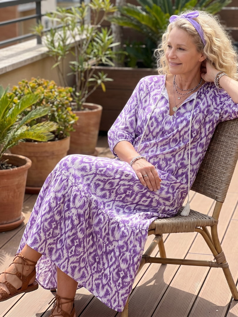 Purple printed midi dress with tassel tie, V-neck, flared skirt, seated model