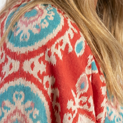 Red paisley print dress fabric detail with teal and white, short-sleeve V-neck