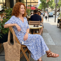 Blue printed midi dress with tassel tie neck, short sleeves, seated outdoor view