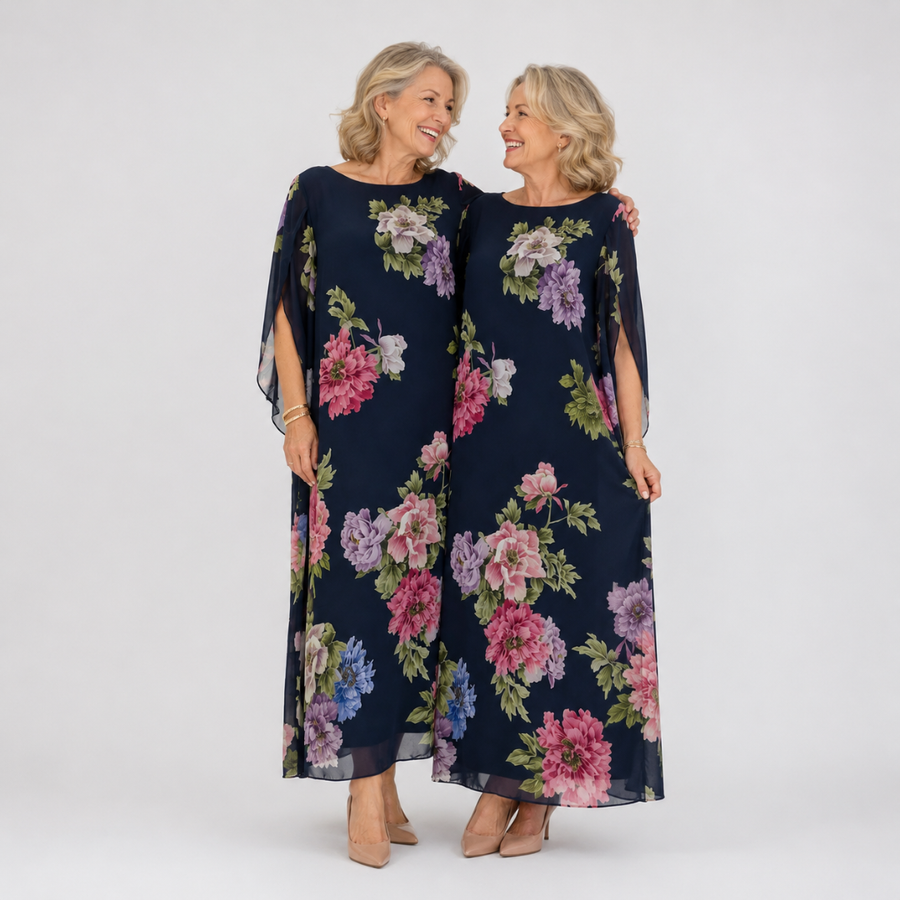 Floral maxi dress in dark blue with pink and lavender blooms, sheer cape sleeves