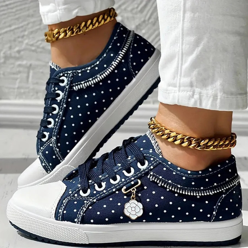 Navy lace-up floral sneakers with white dots and stitched trim, chunky rubber sole.