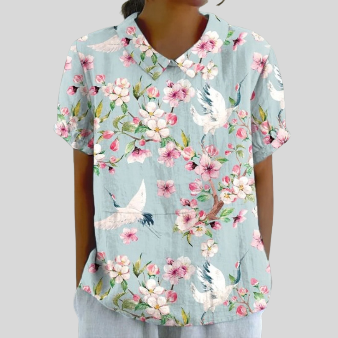 Top leggero azzurro con stampa floreale rosa e uccellini, scollo a V